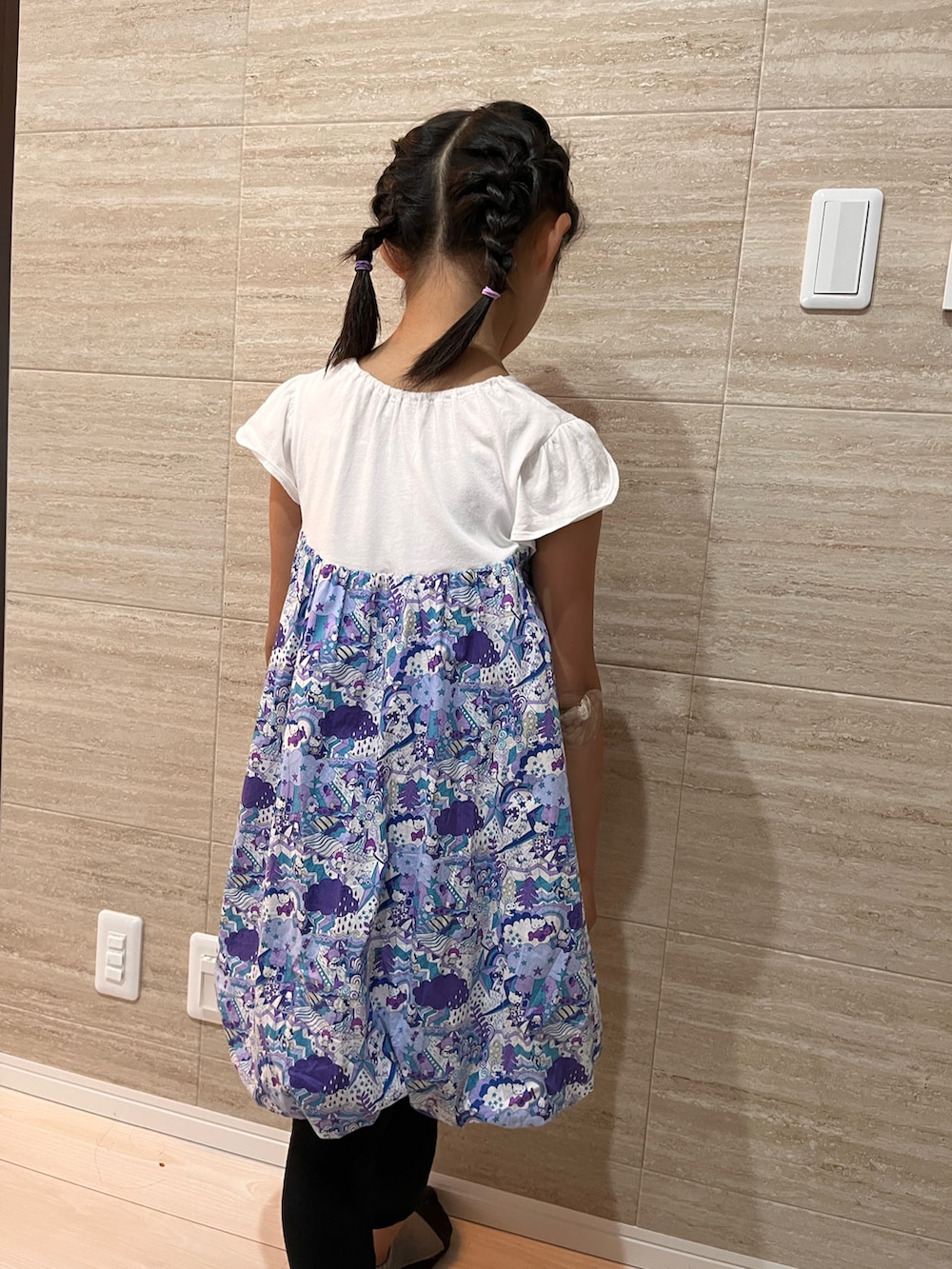 ブルー系のワンピース、ブラック系のその他パンツを着用したキッズの秋コーディネートの3枚目の写真