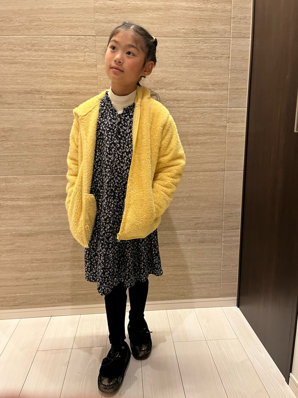 イエロー系のジャケット/アウター、ホワイト系のTシャツ/カットソー、ブルー系のワンピースを着用したキッズの冬コーディネートの2枚目の写真