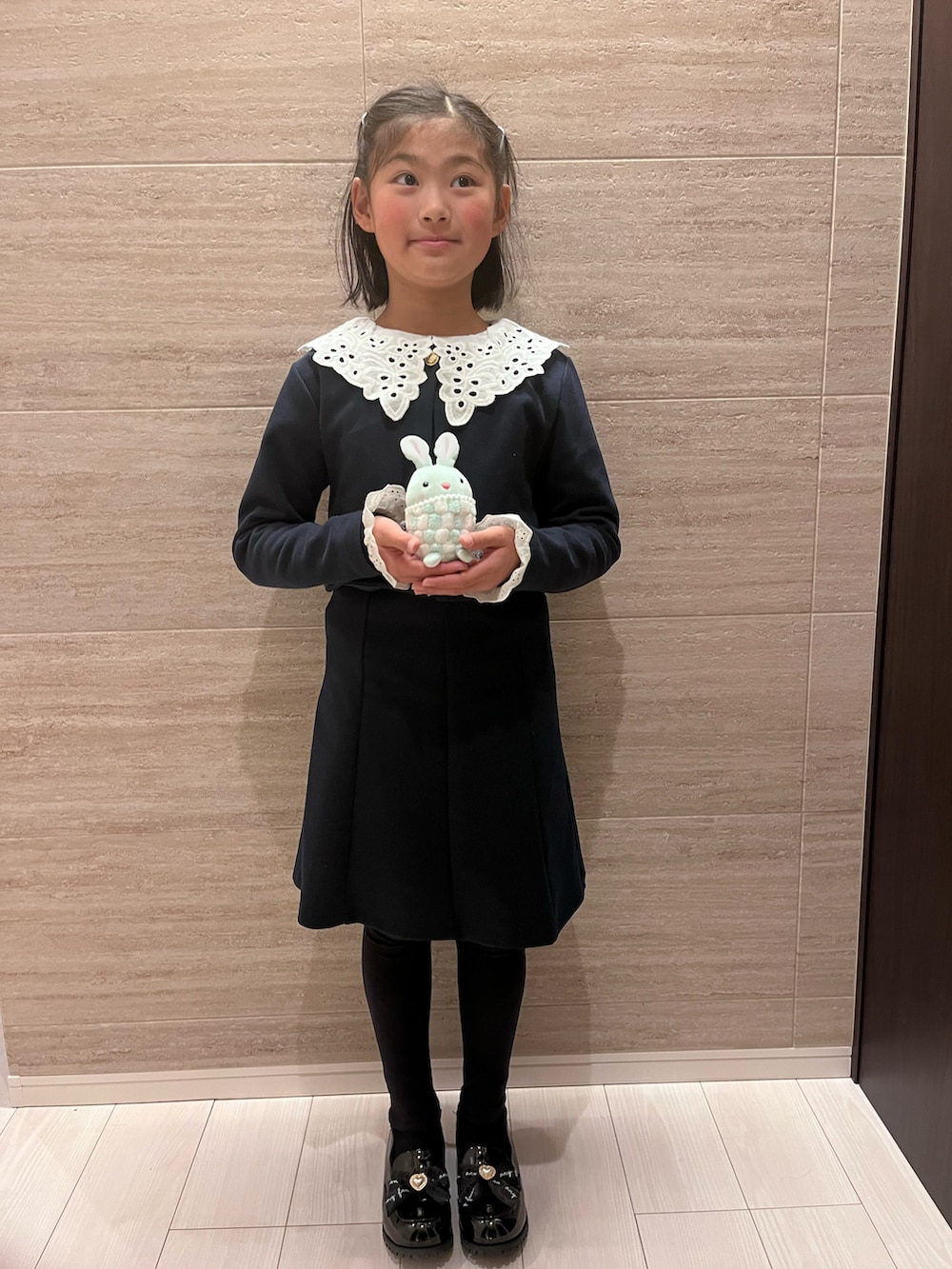 ブラック系のワンピースを着用したキッズの春コーディネートの2枚目の写真