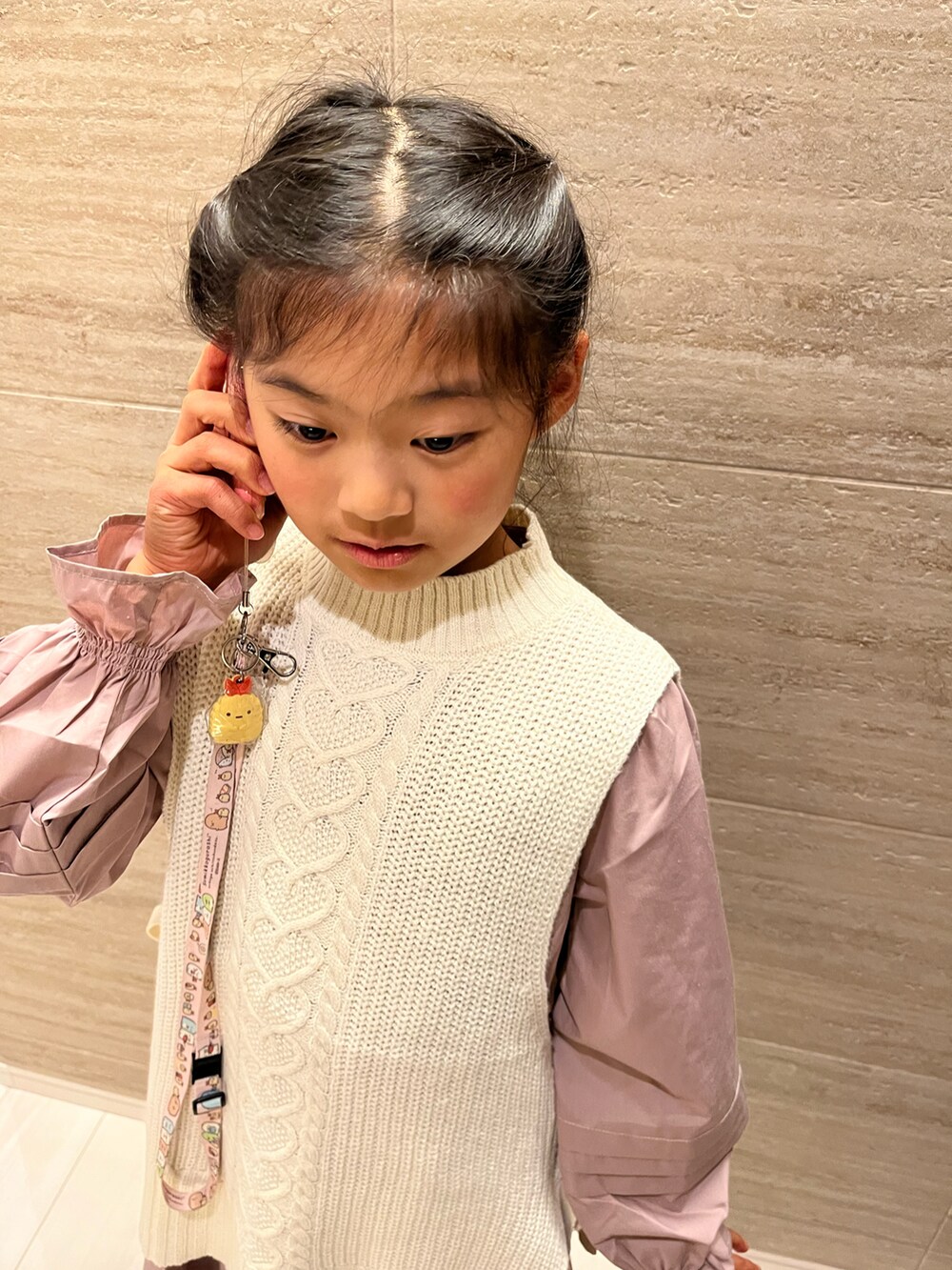 ホワイト系のカーディガン/ボレロ、ピンク系のワンピース、ブラック系のバレエシューズを着用したキッズの冬コーディネートの3枚目の写真