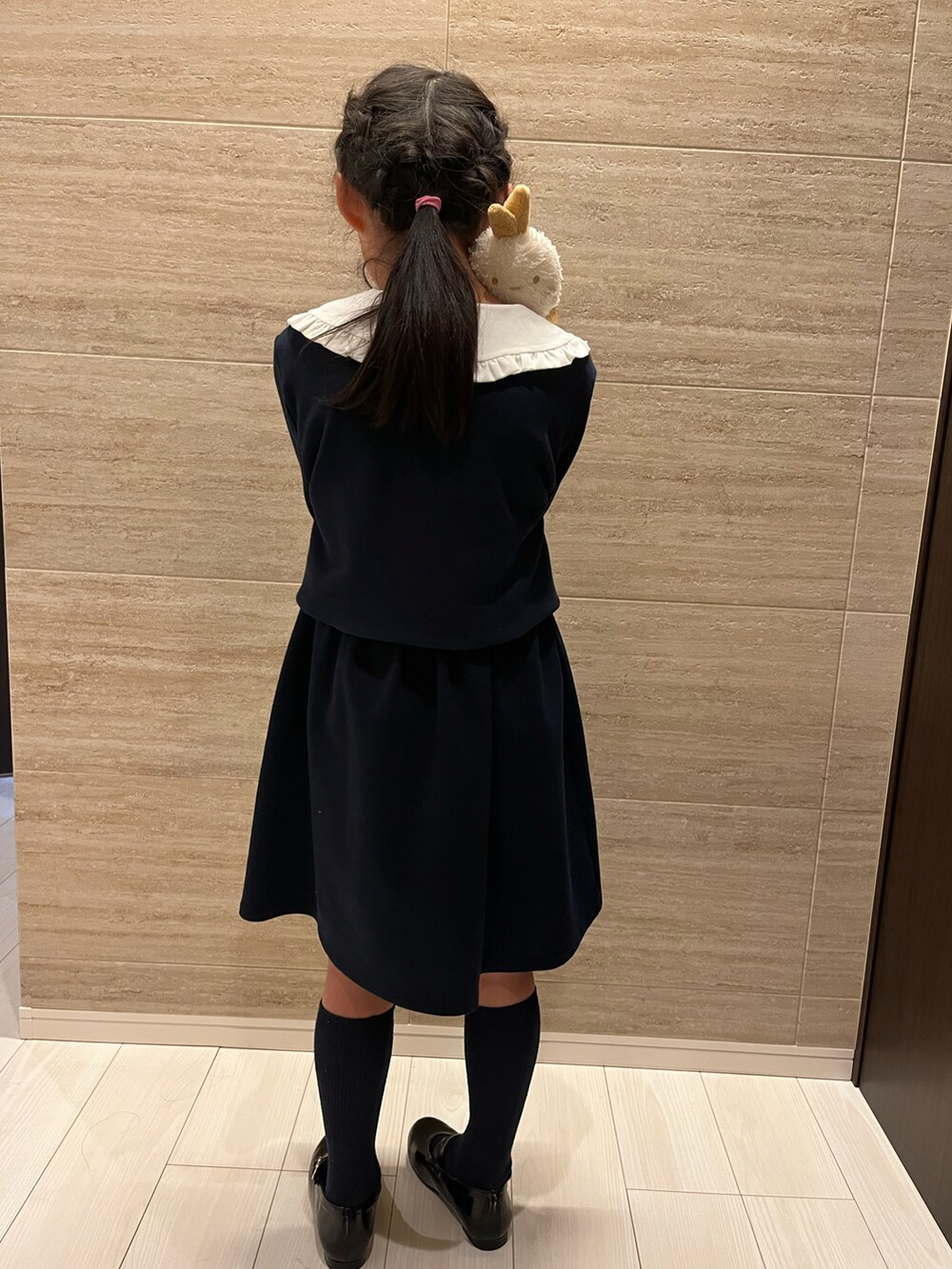 ブラック系のワンピース、ブラック系のパンプスを着用したキッズの春コーディネートの3枚目の写真