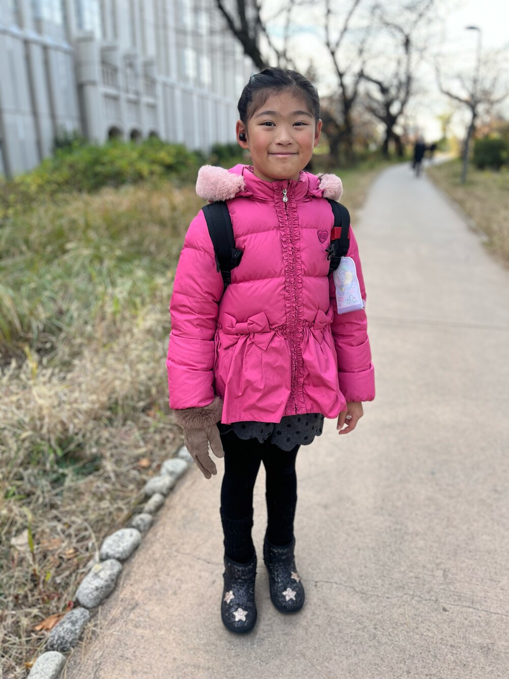 ピンク系のダウンジャケット/コートを着用したキッズの冬コーディネートの2枚目の写真