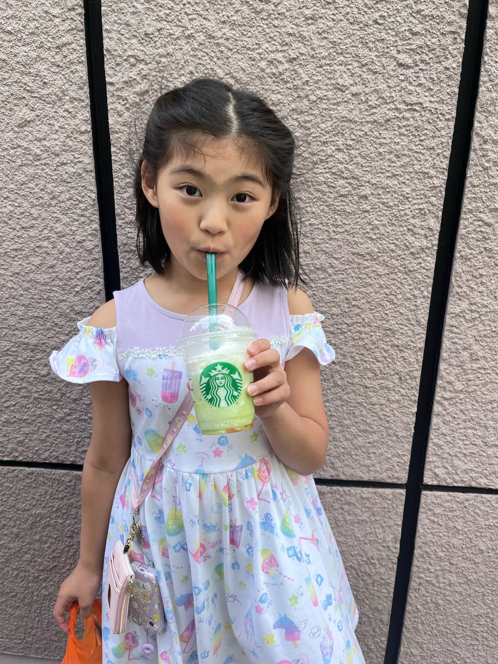 ピンク系のワンピース、ピンク系のスニーカーを着用したキッズの春コーディネートの2枚目の写真