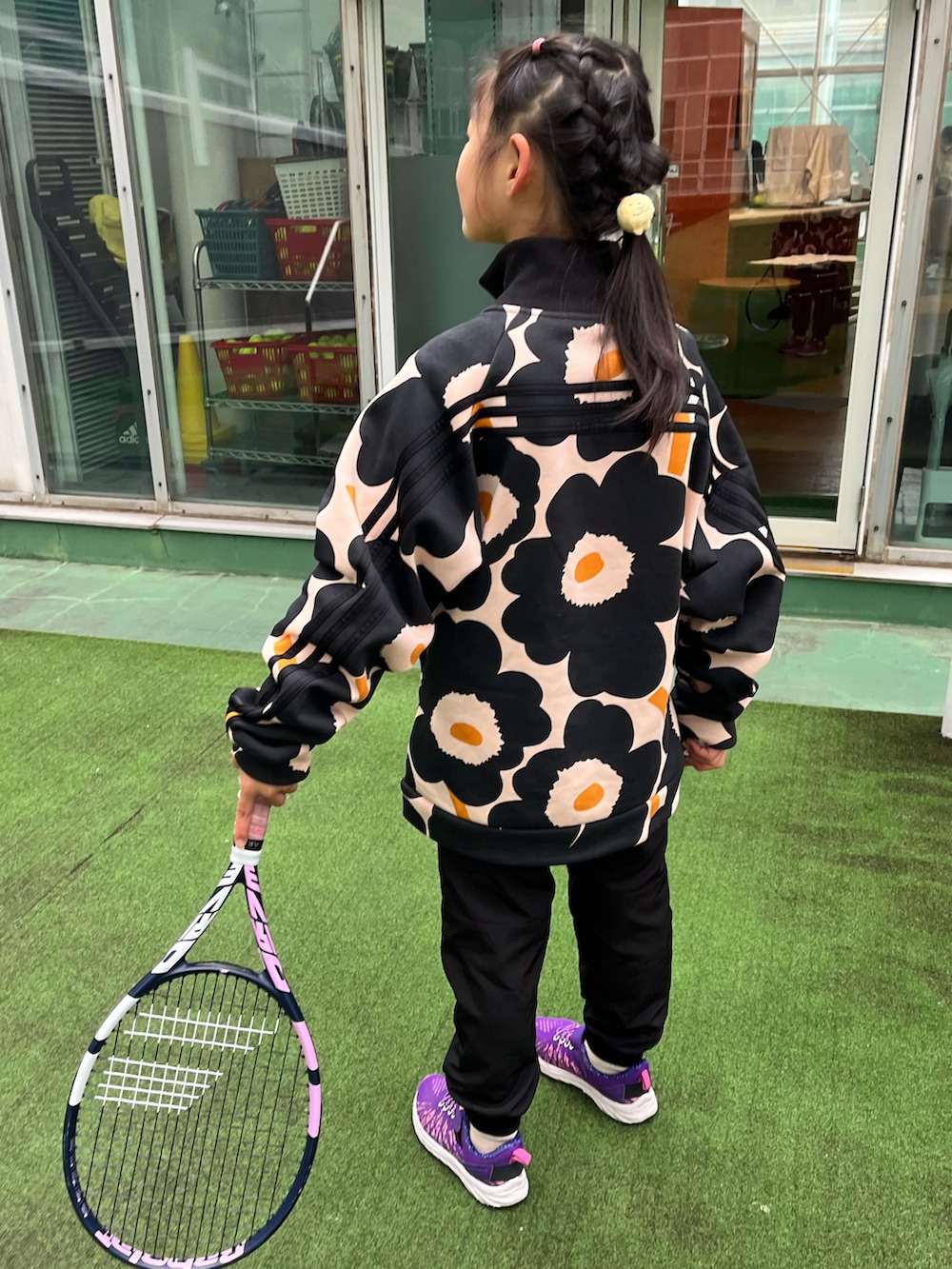 ブラック系のパンツ、パープル系のスニーカー、ブラック系のスポーツグッズを着用したキッズの冬コーディネートの3枚目の写真