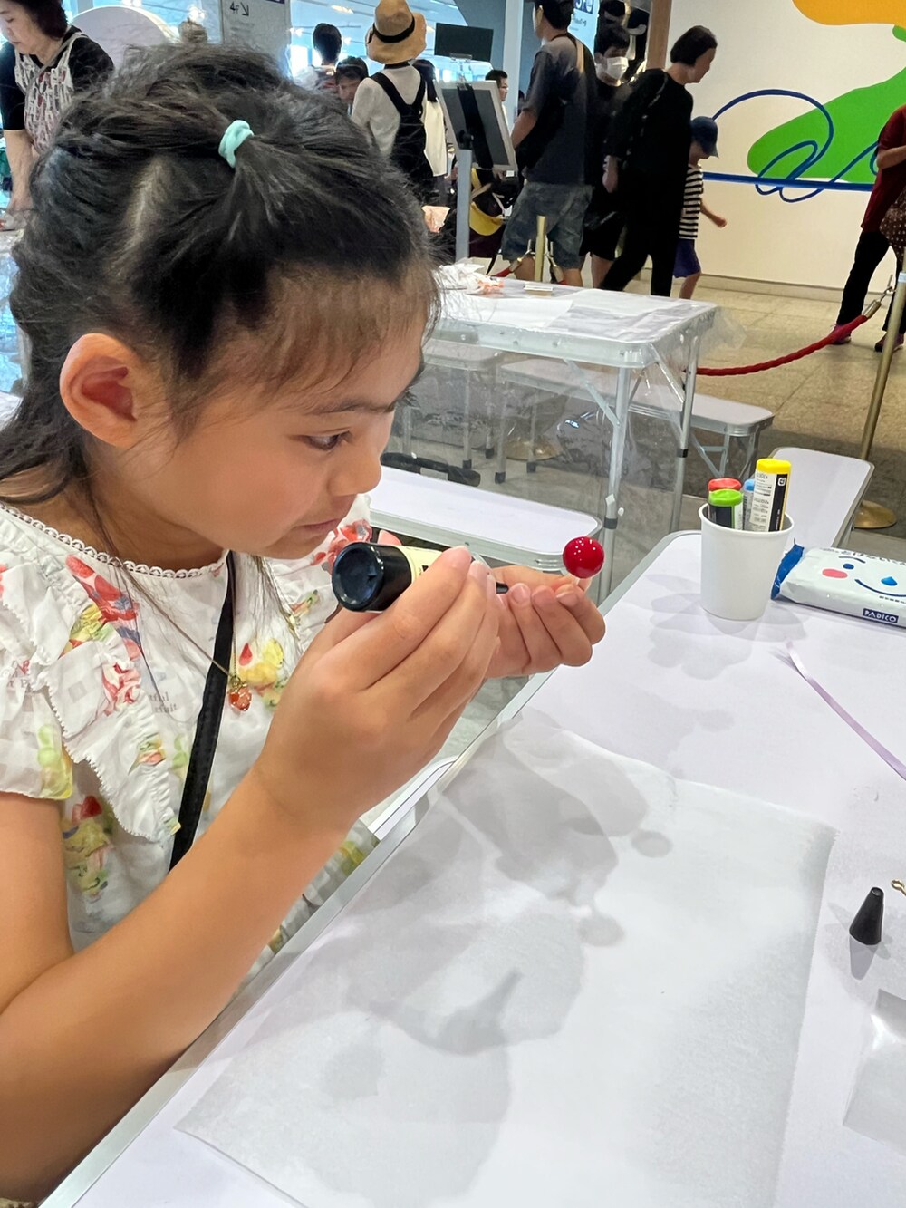 ホワイト系のワンピース、ベージュ系のかごバッグ、パープル系のサンダルを着用したキッズの夏コーディネートの5枚目の写真