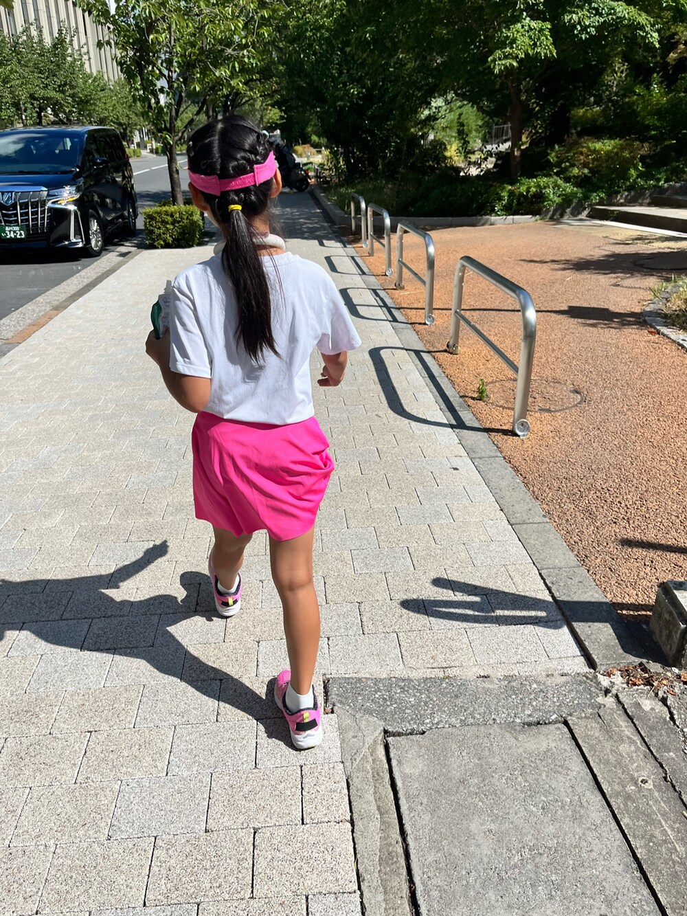 ホワイト系のTシャツ/カットソー、ピンク系のスニーカー、ピンク系のサンバイザーを着用したキッズの夏コーディネートの4枚目の写真