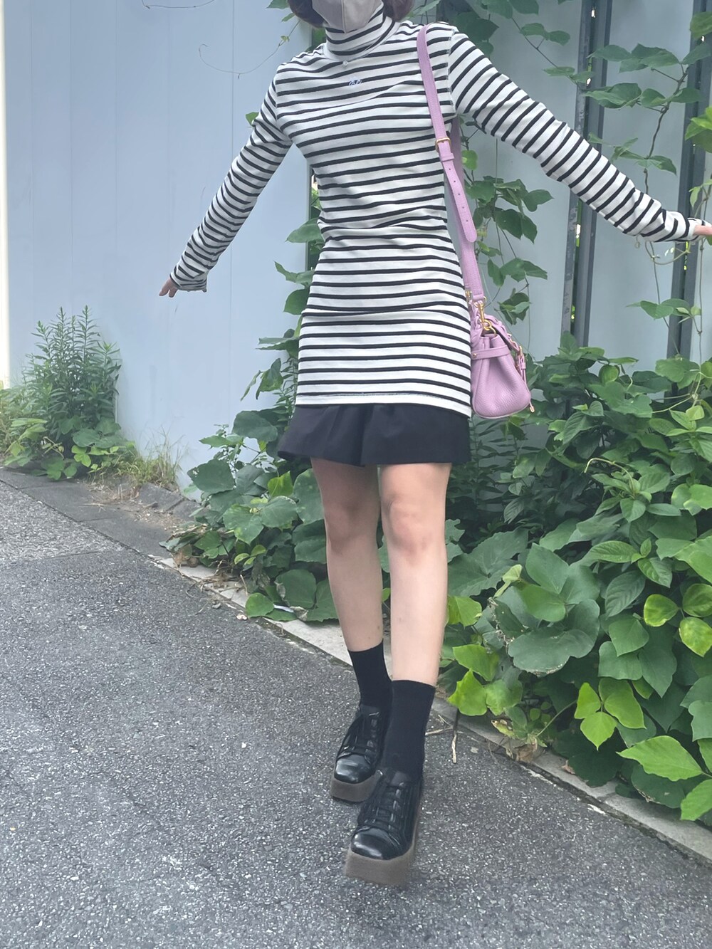 ホワイト系のワンピース、ピンク系のバッグ、ブラック系のその他パンツを着用したレディースの秋コーディネートの2枚目の写真