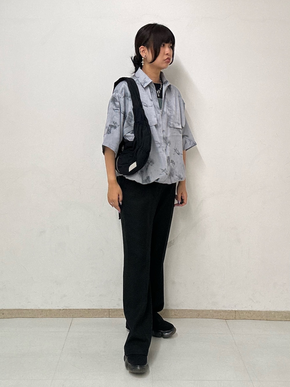 ブラック系のその他パンツ、ブラック系のショルダーバッグ、グレー系のシャツ/ブラウスを着用したレディースの夏コーディネートの2枚目の写真