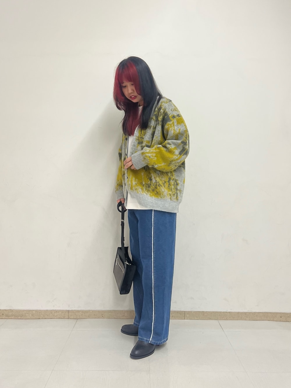 イエロー系のカーディガン/ボレロ、ホワイト系のTシャツ/カットソー、ブルー系のデニムパンツを着用したレディースの秋コーディネートの2枚目の写真