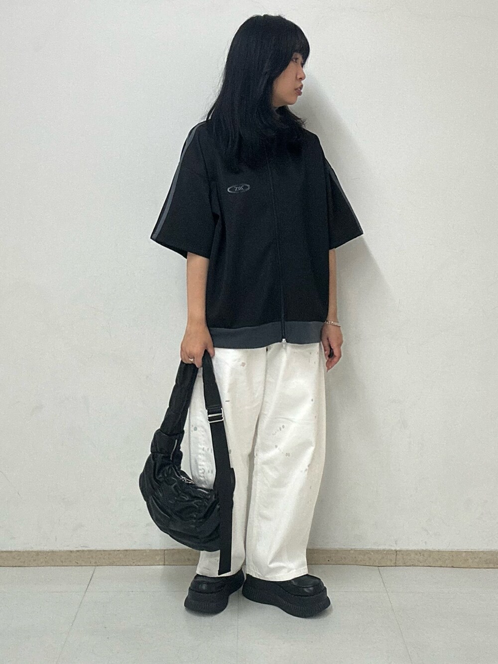 ブラック系のTシャツ/カットソー、ブラック系のショルダーバッグ、シルバー系のブレスレットを着用したレディースの夏コーディネートの2枚目の写真