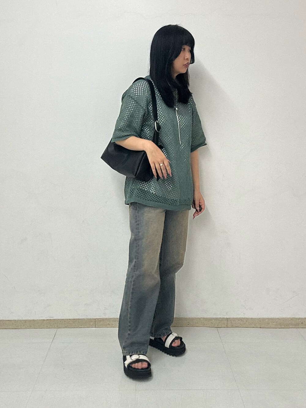 グレー系のサンダル、ブラック系のショルダーバッグ、グリーン系のTシャツ/カットソーを着用したレディースの夏コーディネートの2枚目の写真