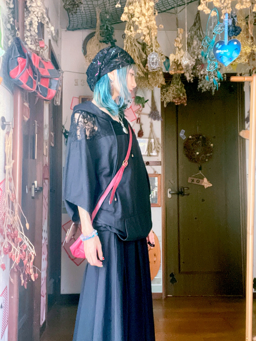 レッド系のショルダーバッグを着用したレディースの秋コーディネートの2枚目の写真