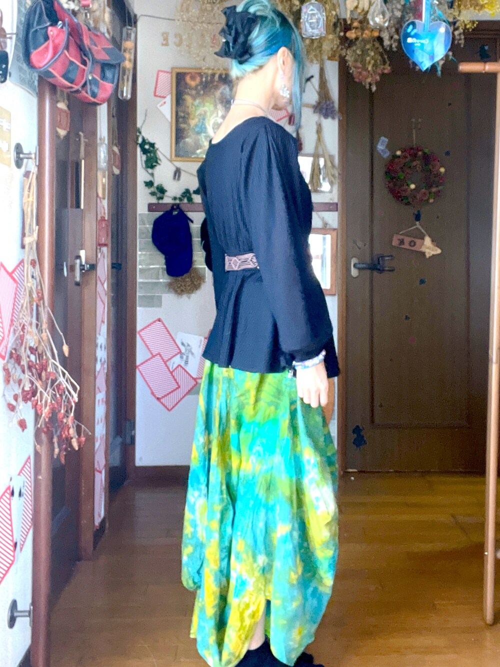 グリーン系のスカートを着用したレディースの秋コーディネートの2枚目の写真