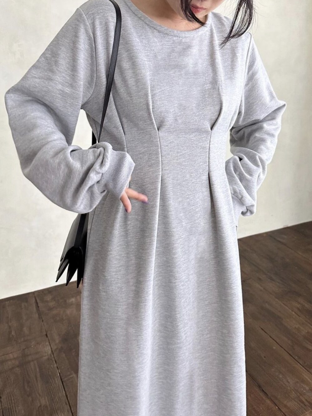 グレー系のワンピース、ブラック系のショルダーバッグを着用したレディースの秋コーディネートの2枚目の写真