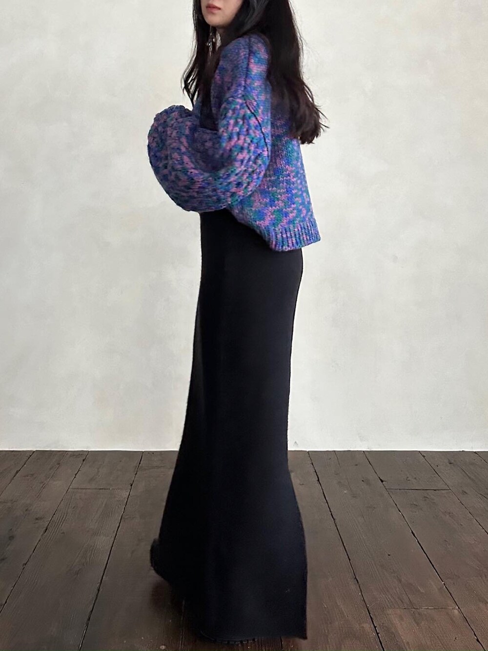 グリーン系のニット/セーター、ブラック系のスカートを着用したレディースの秋コーディネートの2枚目の写真