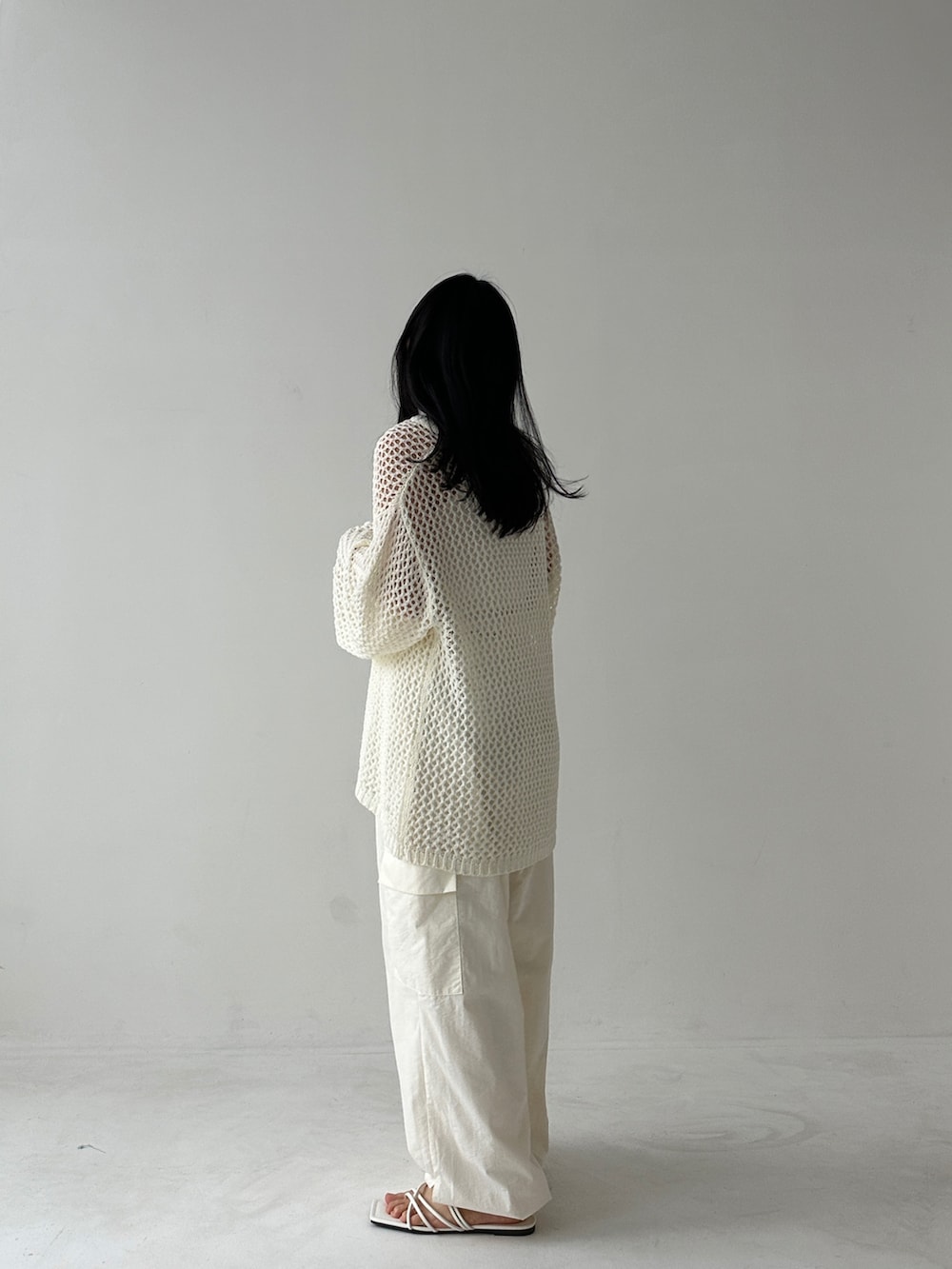 ホワイト系のニット/セーター、ホワイト系のカーゴパンツを着用したレディースの春コーディネートの3枚目の写真