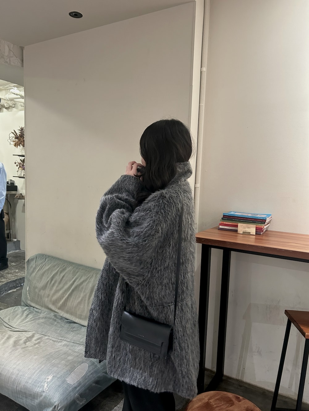 グレー系のステンカラーコートを着用したレディースの冬コーディネートの2枚目の写真