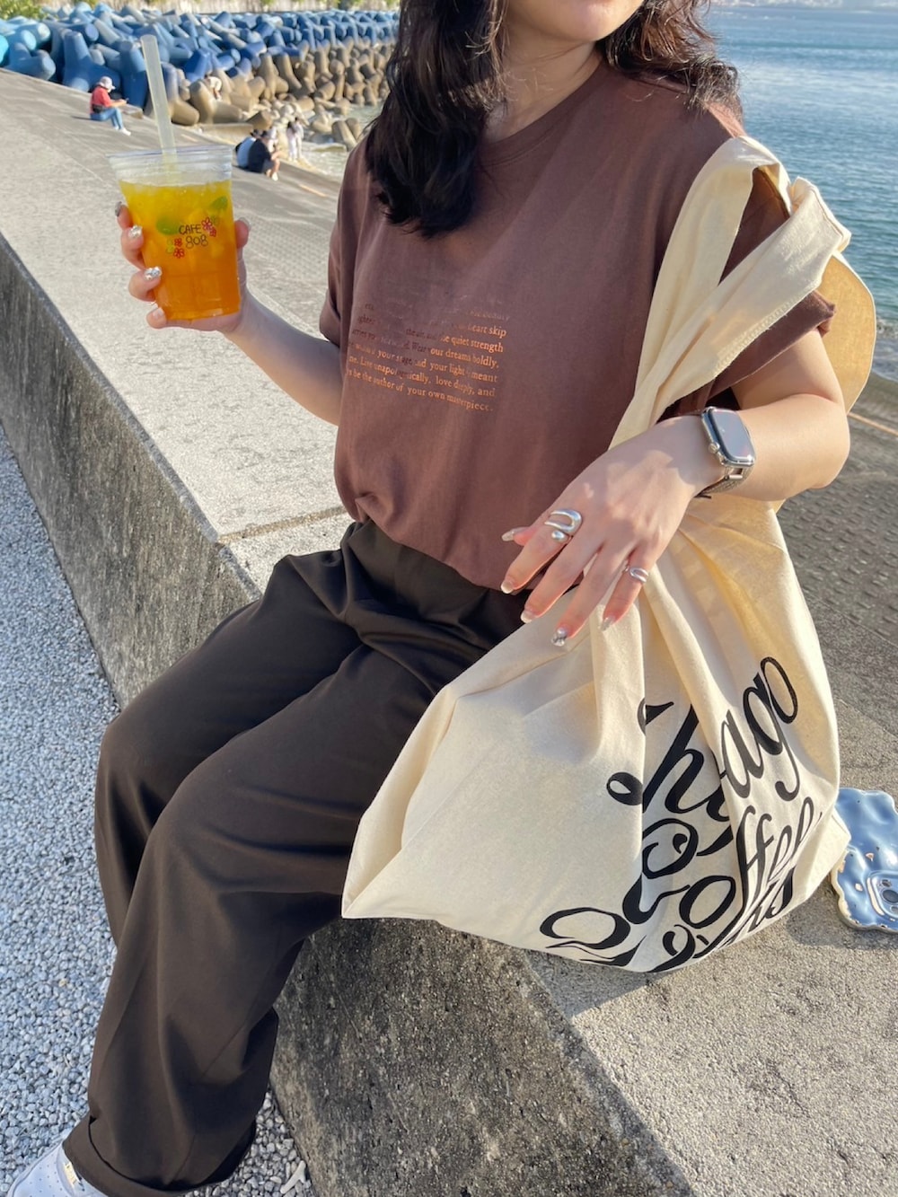 ブラウン系のTシャツ/カットソー、グレー系のスニーカーを着用したレディースの春コーディネートの2枚目の写真