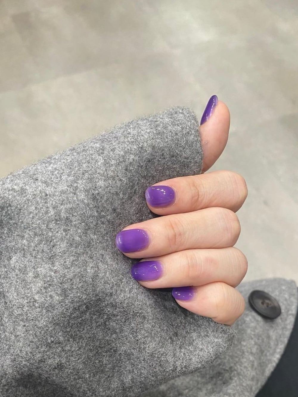 グレー系のニット/セーター、グレー系のステンカラーコート、ブラック系のスラックスを着用したレディースの秋コーディネートの3枚目の写真