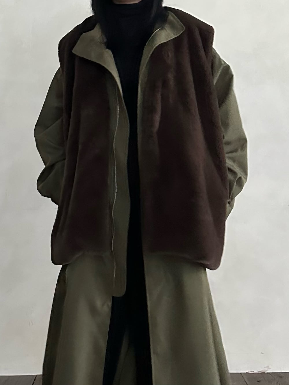 ブラウン系のベスト、グリーン系のモッズコートを着用したレディースの冬コーディネートの2枚目の写真