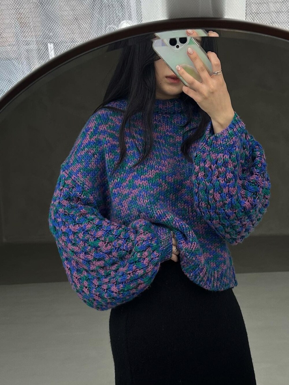 グリーン系のニット/セーター、ブラック系のスカートを着用したレディースの秋コーディネートの3枚目の写真