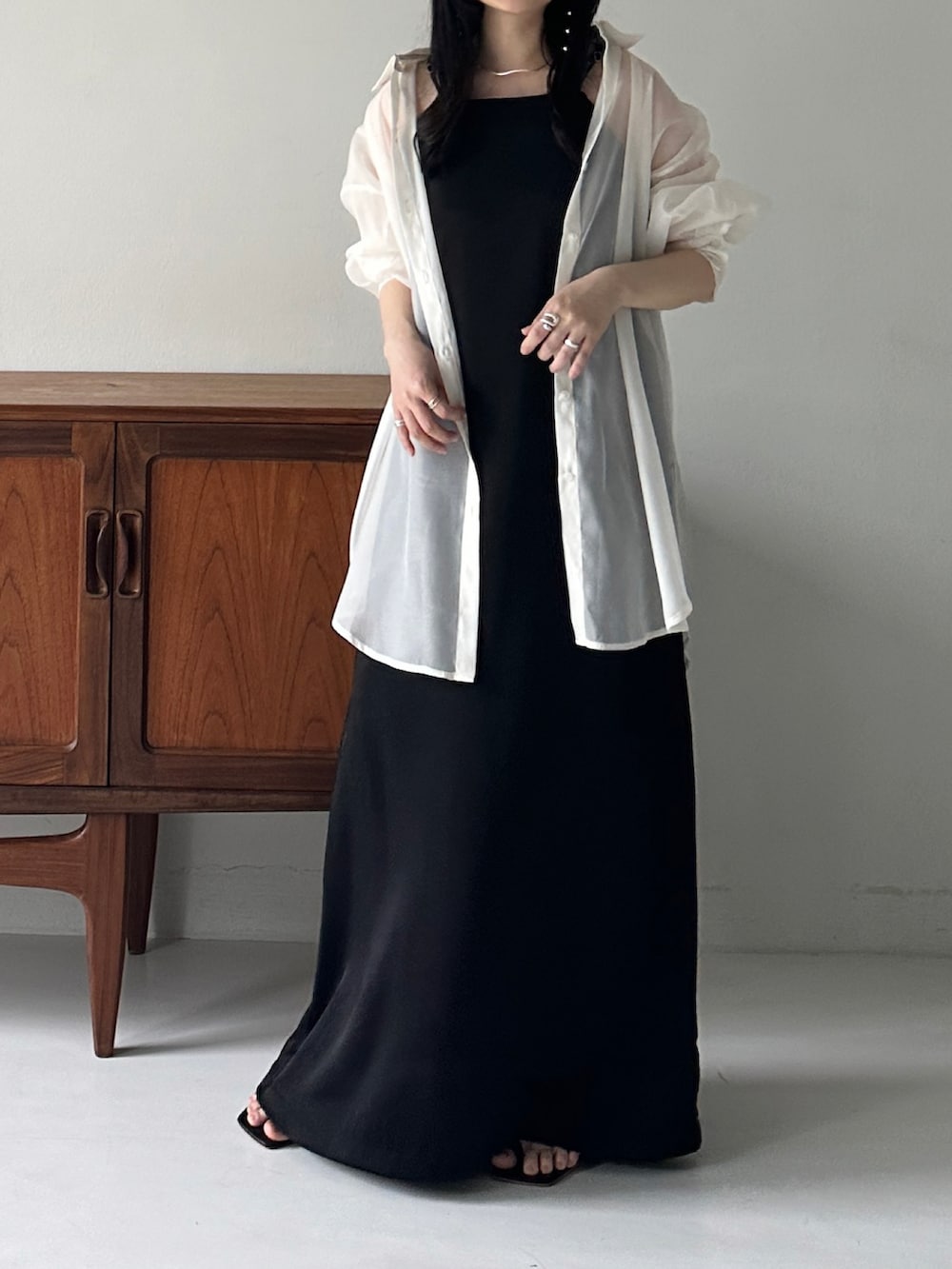 ブラック系のワンピースを着用したレディースの春コーディネートの2枚目の写真