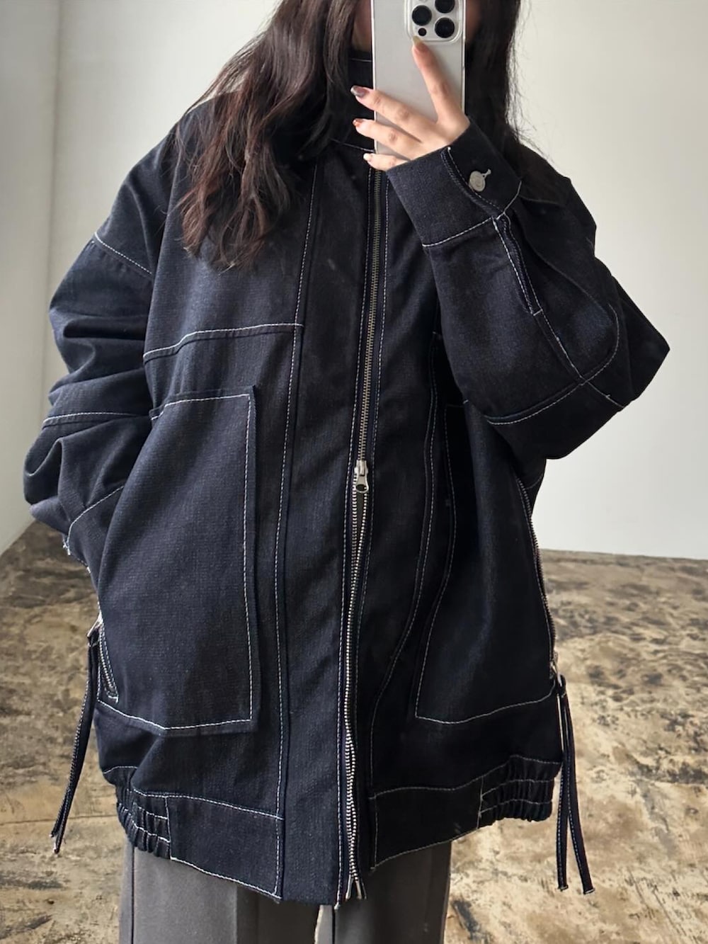 ブラック系のブルゾン、グレー系のパンツを着用したレディースの冬コーディネートの4枚目の写真