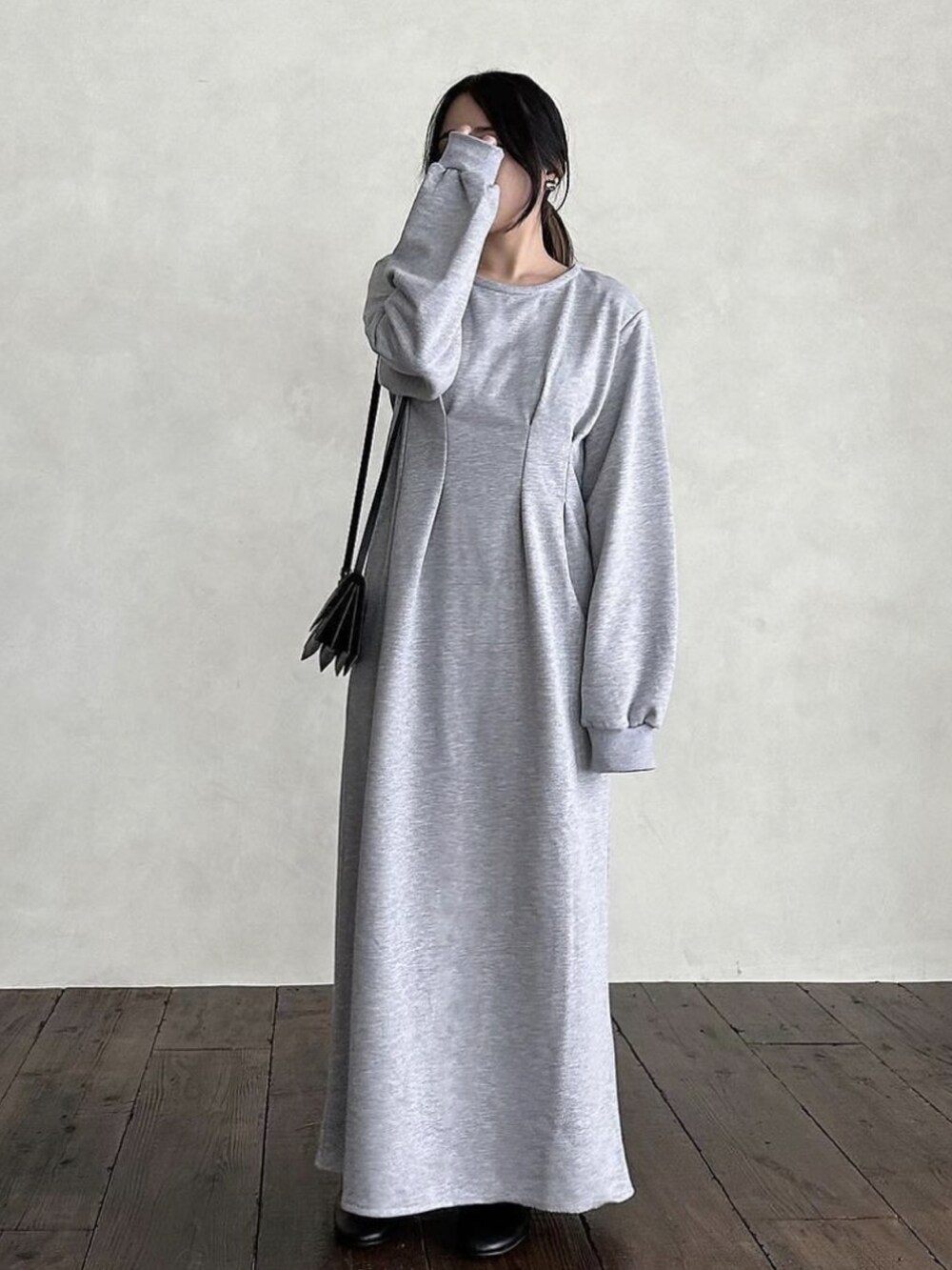 グレー系のワンピース、ブラック系のショルダーバッグを着用したレディースの秋コーディネートの3枚目の写真