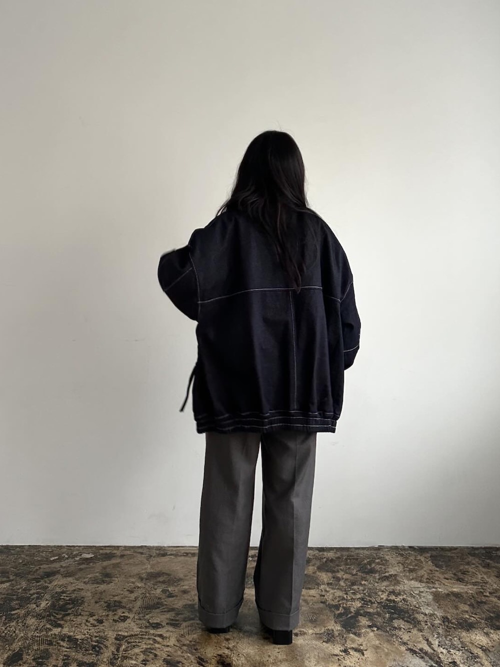 ブラック系のブルゾン、グレー系のパンツを着用したレディースの冬コーディネートの3枚目の写真