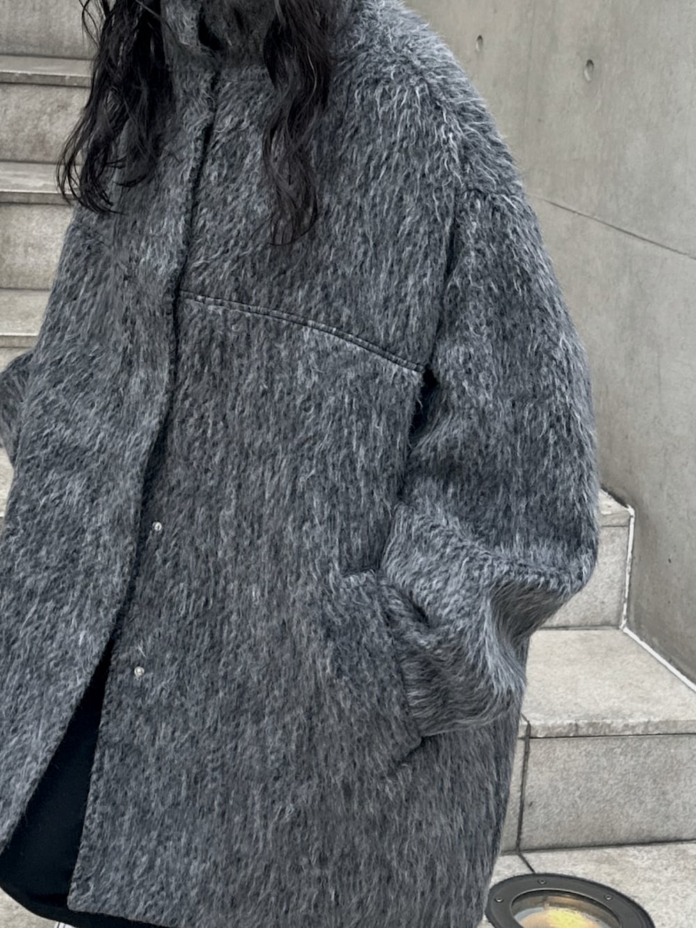 グレー系のステンカラーコートを着用したレディースの冬コーディネートの5枚目の写真