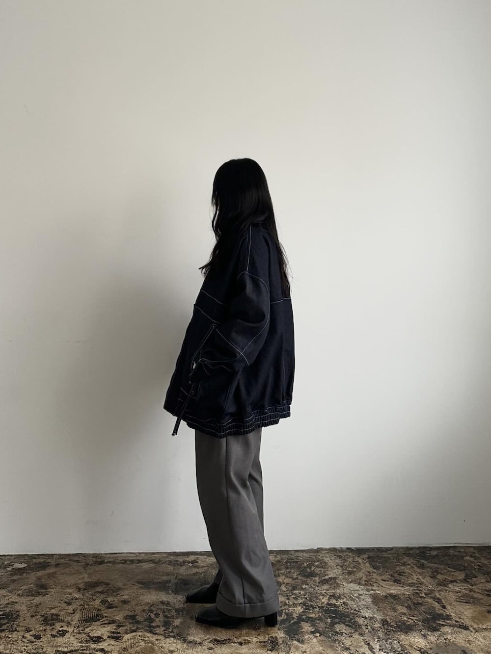 ブラック系のブルゾン、グレー系のパンツを着用したレディースの冬コーディネートの2枚目の写真