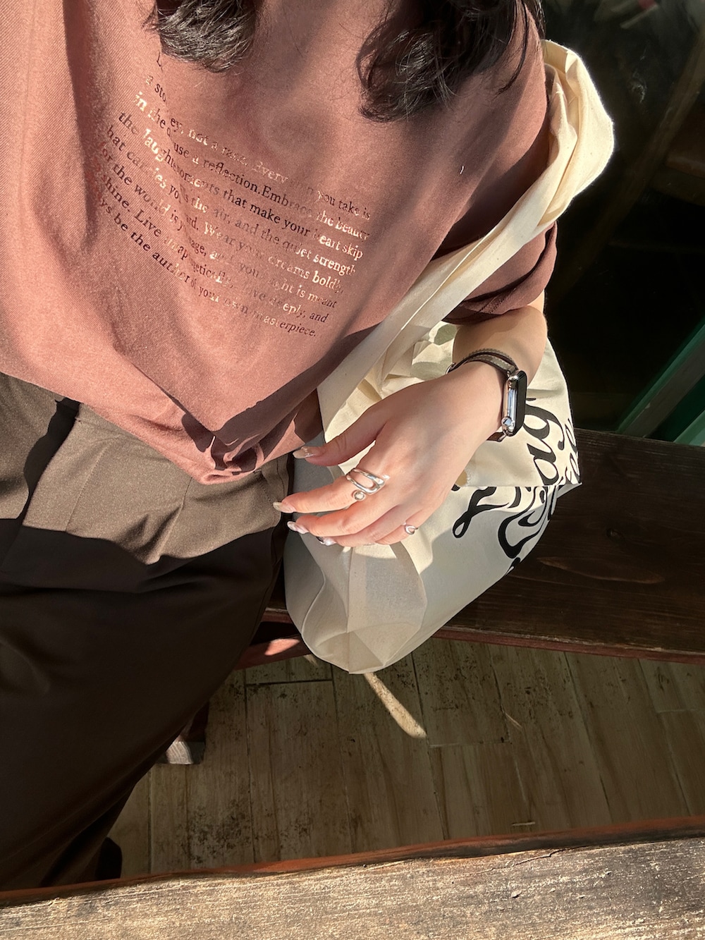 ブラウン系のTシャツ/カットソー、グレー系のスニーカーを着用したレディースの春コーディネートの3枚目の写真