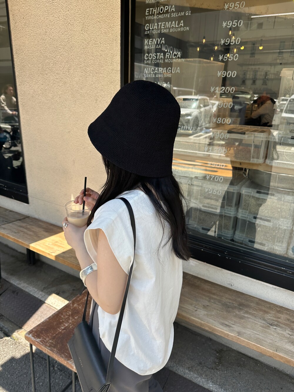 グレー系のその他パンツ、ホワイト系のTシャツ/カットソー、ブラック系のハットを着用したレディースの春コーディネートの2枚目の写真