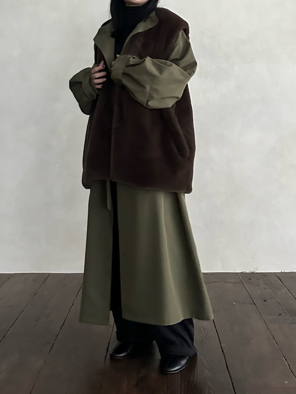 ブラウン系のベスト、グリーン系のモッズコートを着用したレディースの冬コーディネートの3枚目の写真