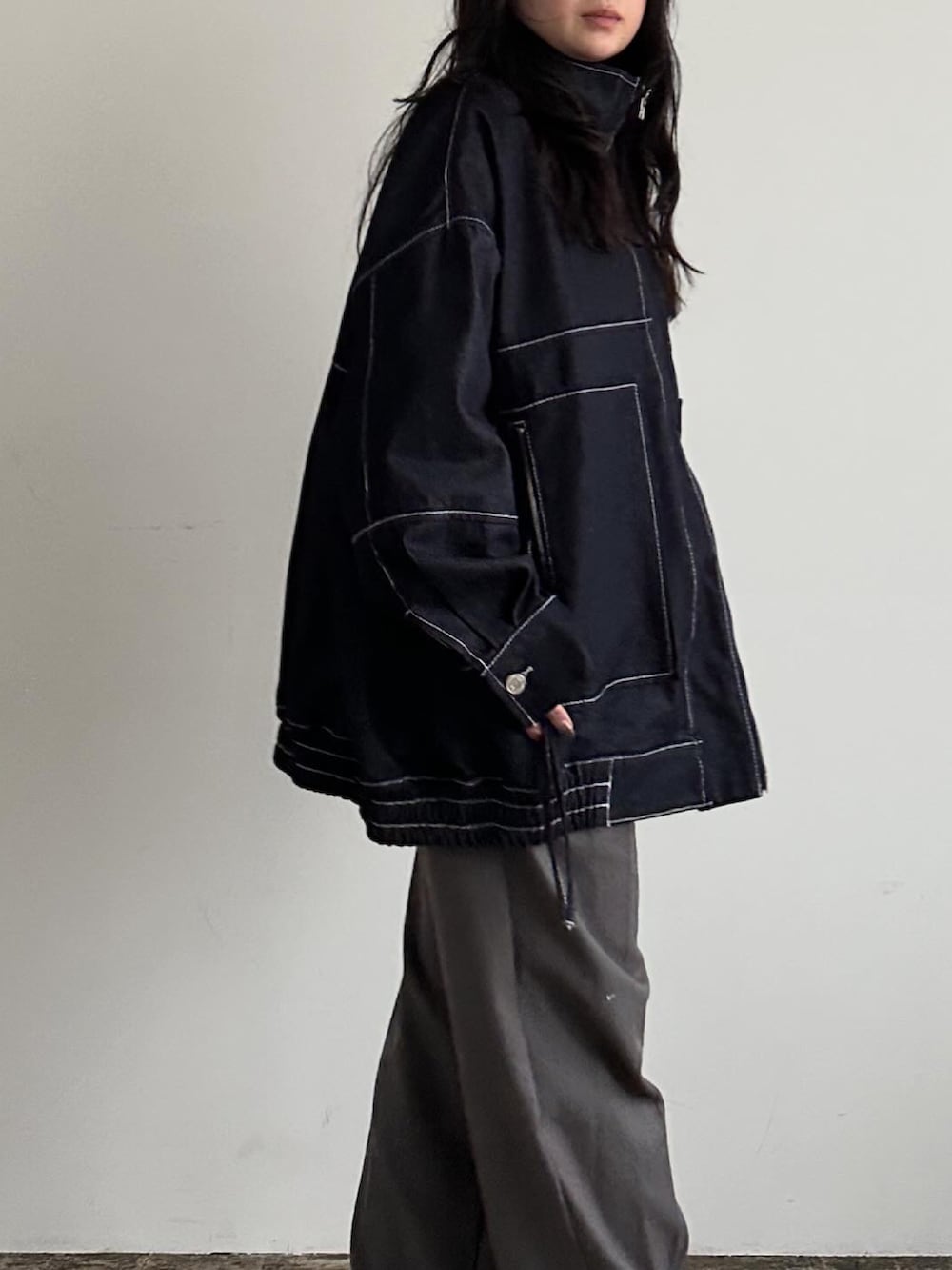 ブラック系のブルゾン、グレー系のパンツを着用したレディースの冬コーディネートの5枚目の写真