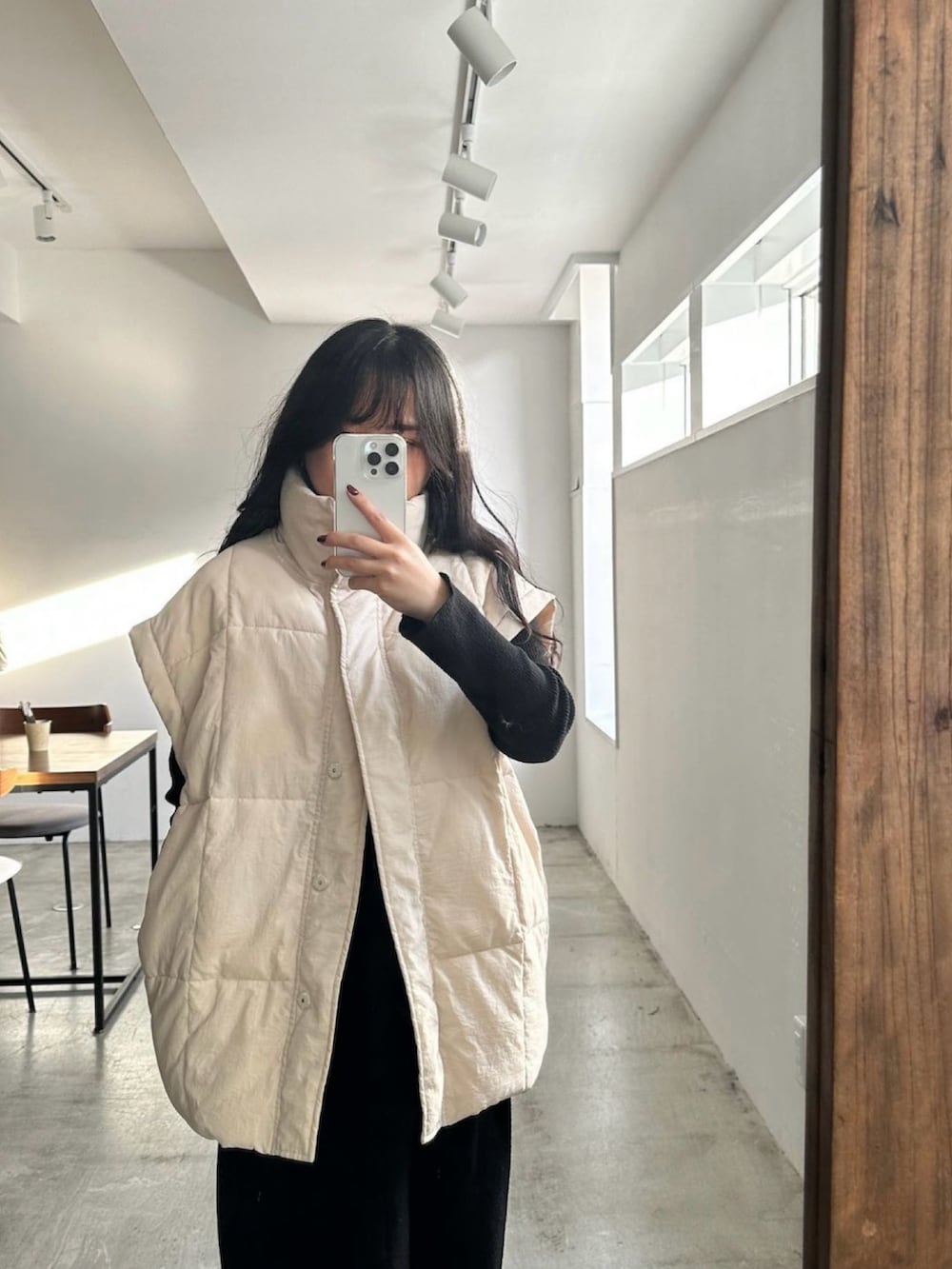 ホワイト系のダウンジャケット/コート、ブラック系のパンツを着用したレディースの冬コーディネートの2枚目の写真