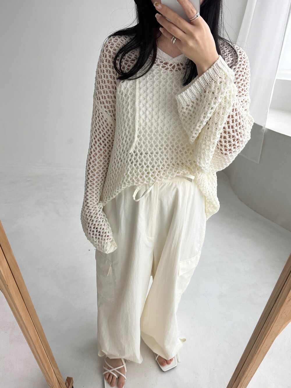 ホワイト系のニット/セーター、ホワイト系のカーゴパンツを着用したレディースの春コーディネートの2枚目の写真