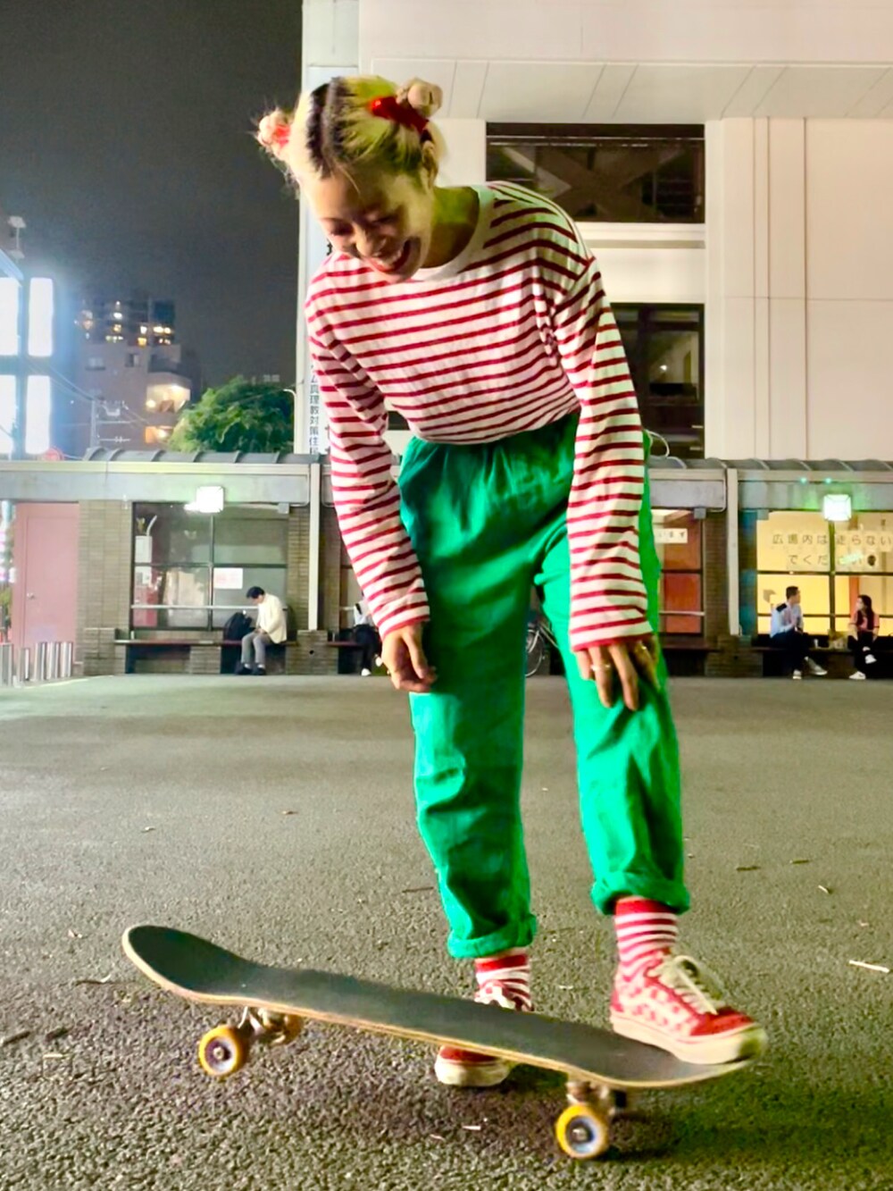 レッド系のTシャツ/カットソー、グリーン系のカーゴパンツ、レッド系のスニーカーを着用したレディースの秋コーディネートの2枚目の写真