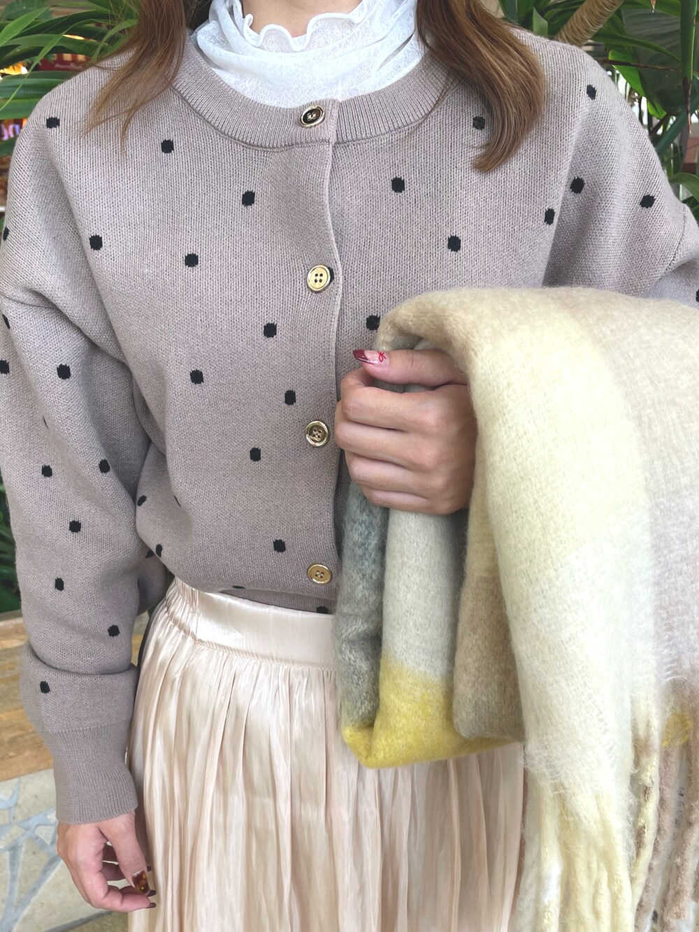 ベージュ系のスカート、ブラウン系のニット/セーター、ホワイト系のブーツを着用したレディースの秋コーディネートの4枚目の写真