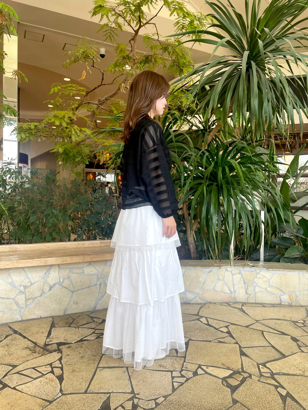 ブラック系のその他トップス、ホワイト系のスカート、ホワイト系のその他シューズを着用したレディースの春コーディネートの2枚目の写真