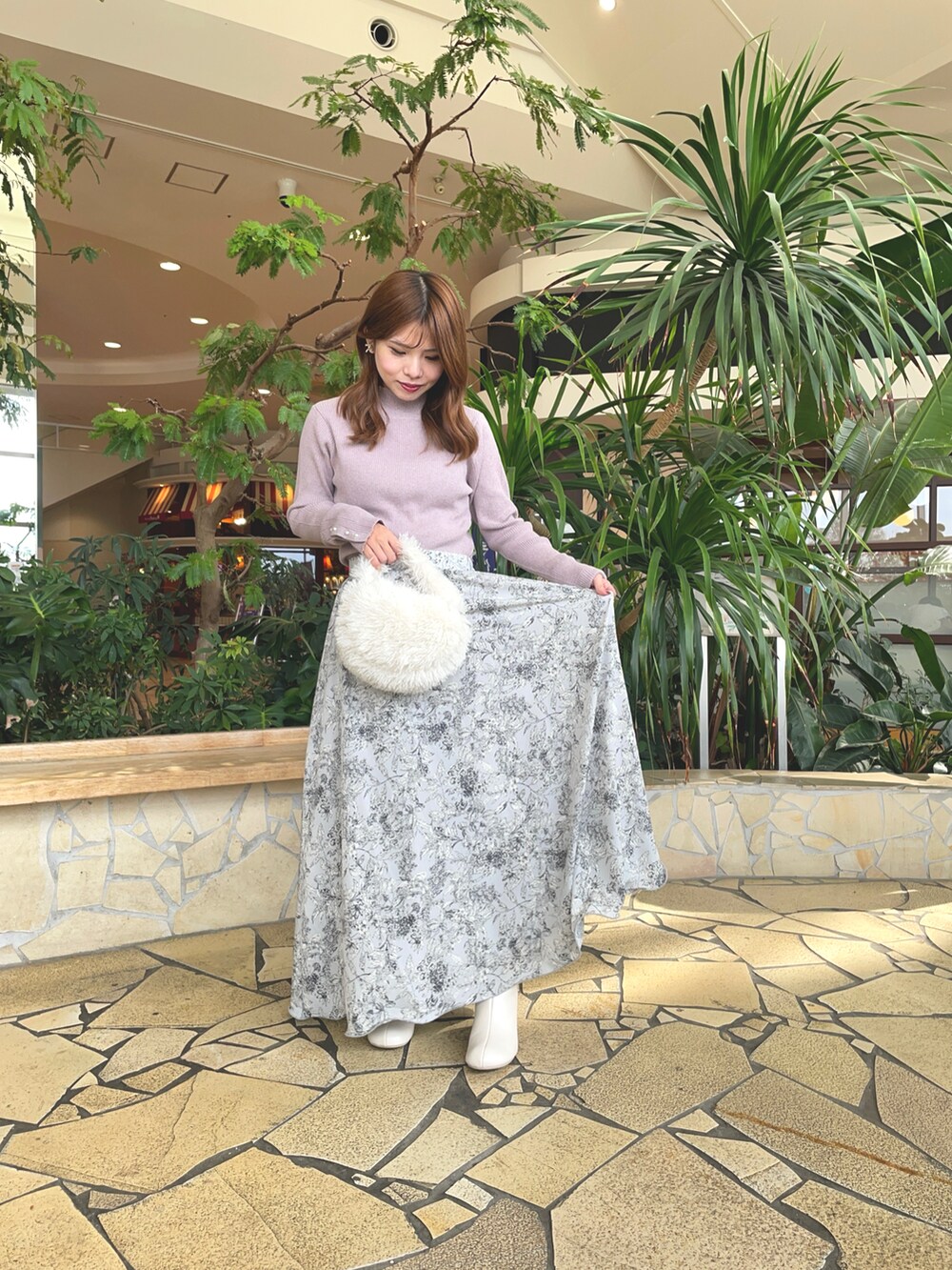 ベージュ系のニット/セーター、ホワイト系のブルゾン、グレー系のスカートを着用したレディースの秋コーディネートの2枚目の写真