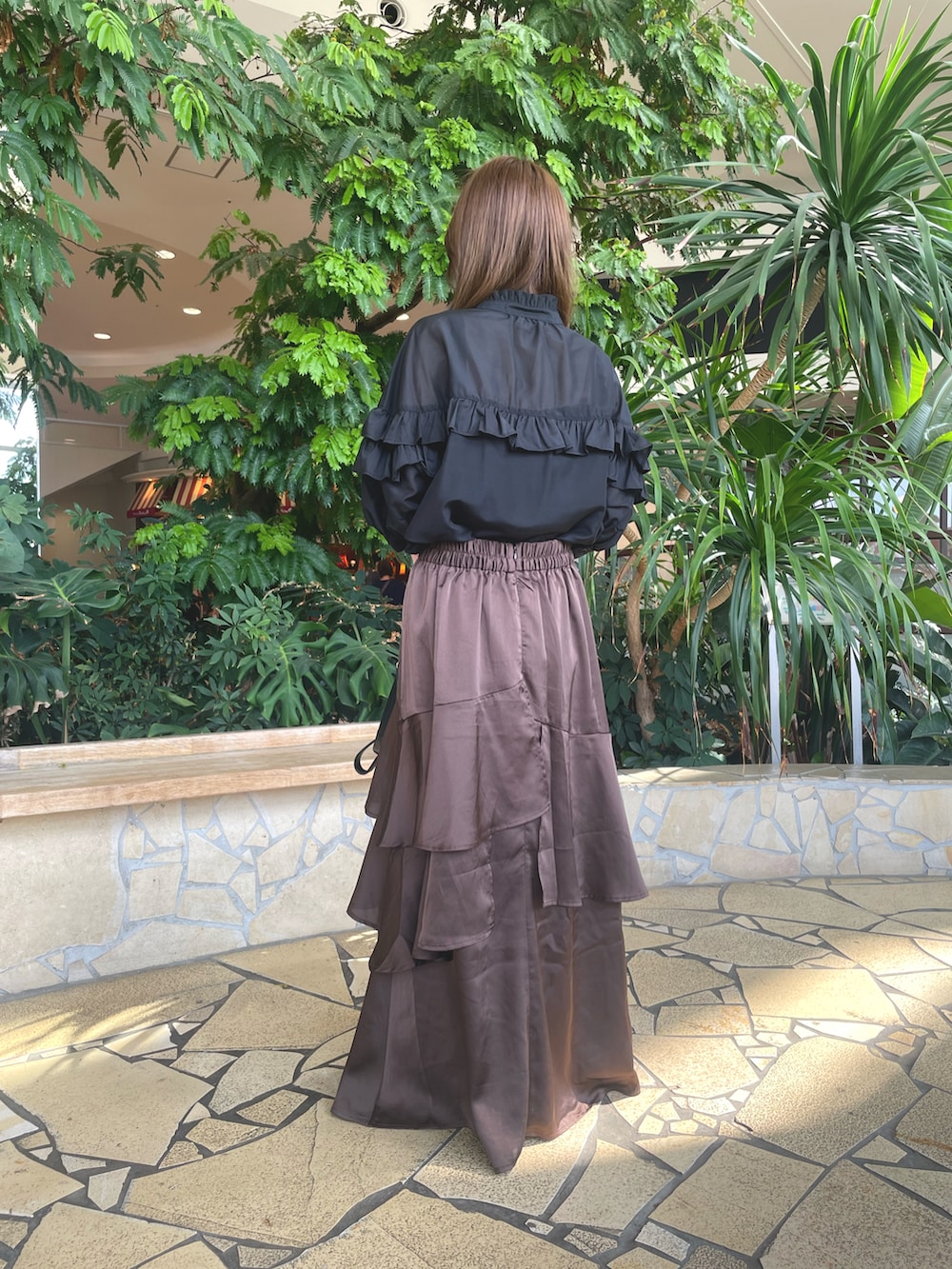 ブラウン系のスカート、ブラック系のハンドバッグ、ブラック系のシャツ/ブラウスを着用したレディースの秋コーディネートの3枚目の写真