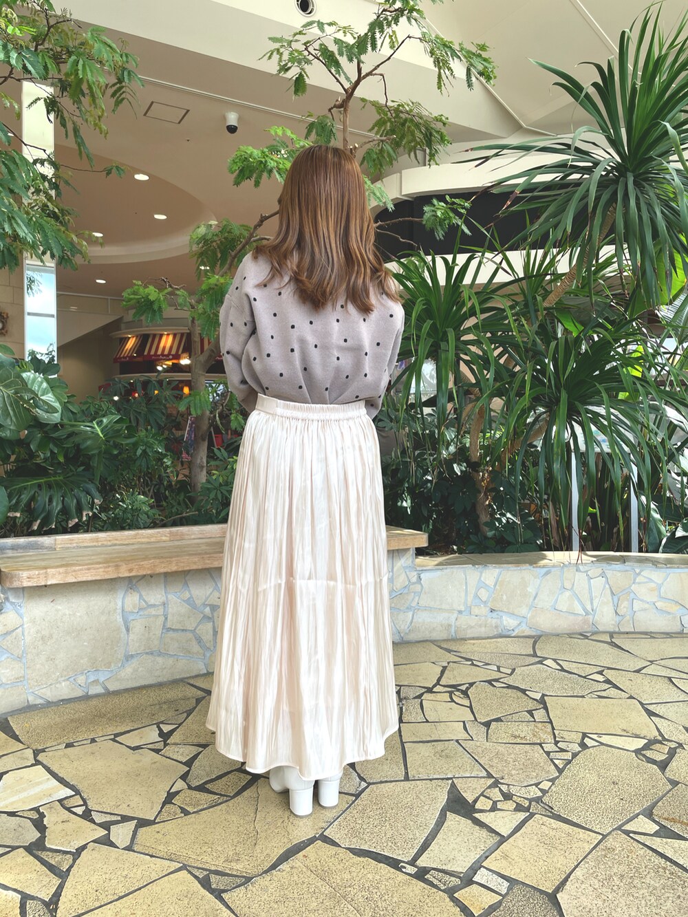 ベージュ系のスカート、ブラウン系のニット/セーター、ホワイト系のブーツを着用したレディースの秋コーディネートの3枚目の写真