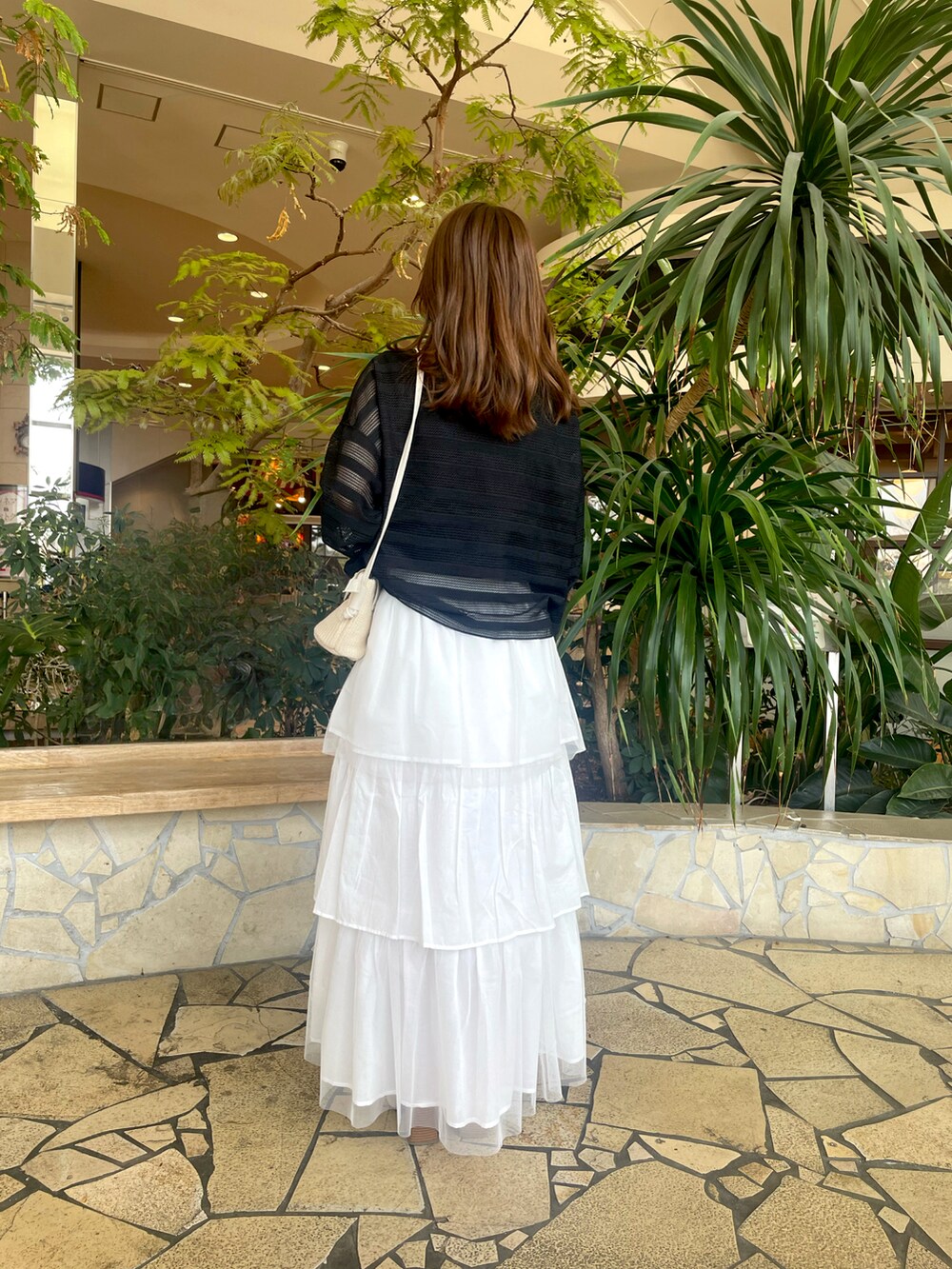 ブラック系のその他トップス、ホワイト系のスカート、ホワイト系のその他シューズを着用したレディースの春コーディネートの3枚目の写真