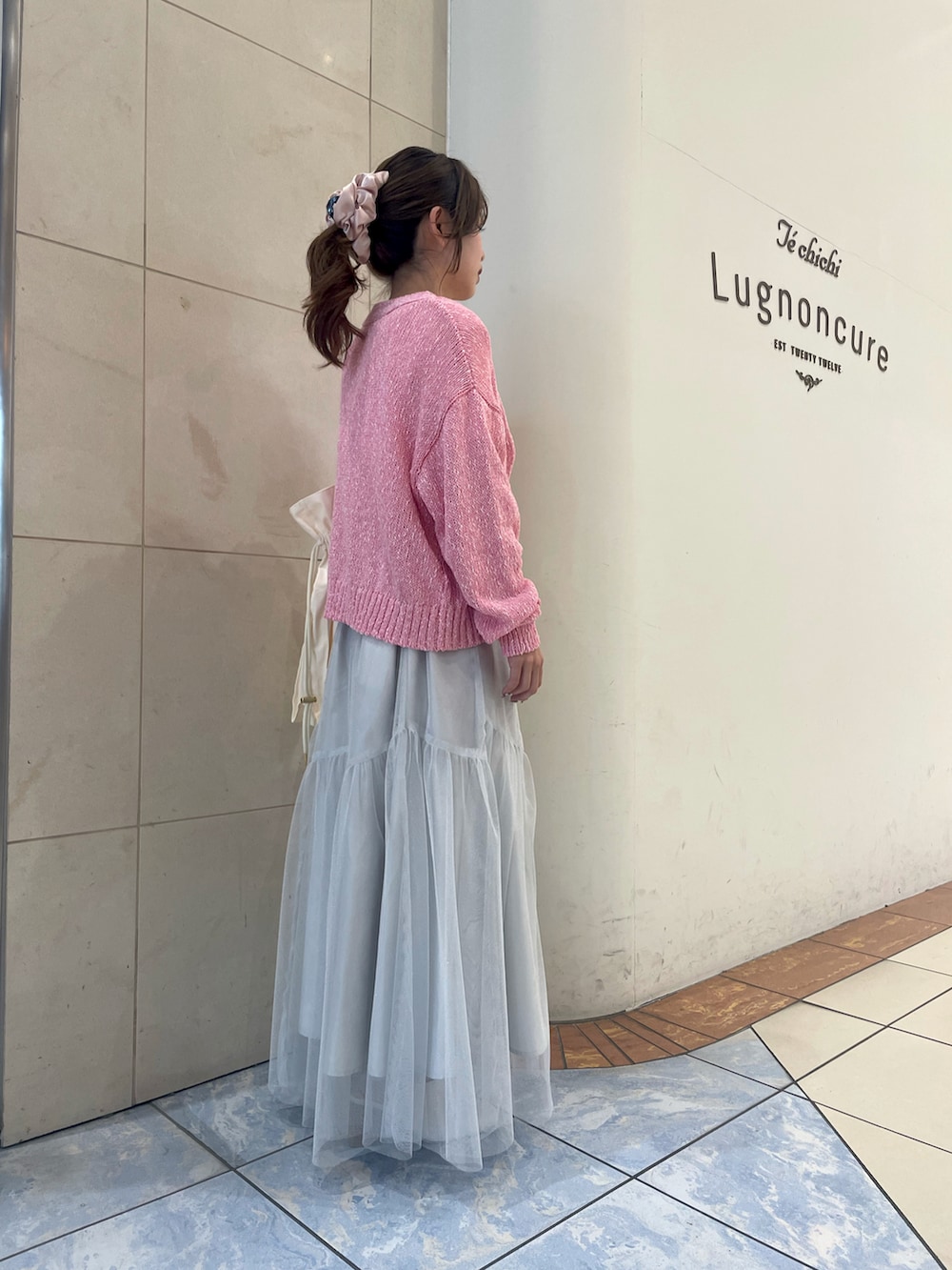 ホワイト系のスカート、ホワイト系のTシャツ/カットソー、ピンク系のカーディガン/ボレロを着用したレディースの春コーディネートの2枚目の写真