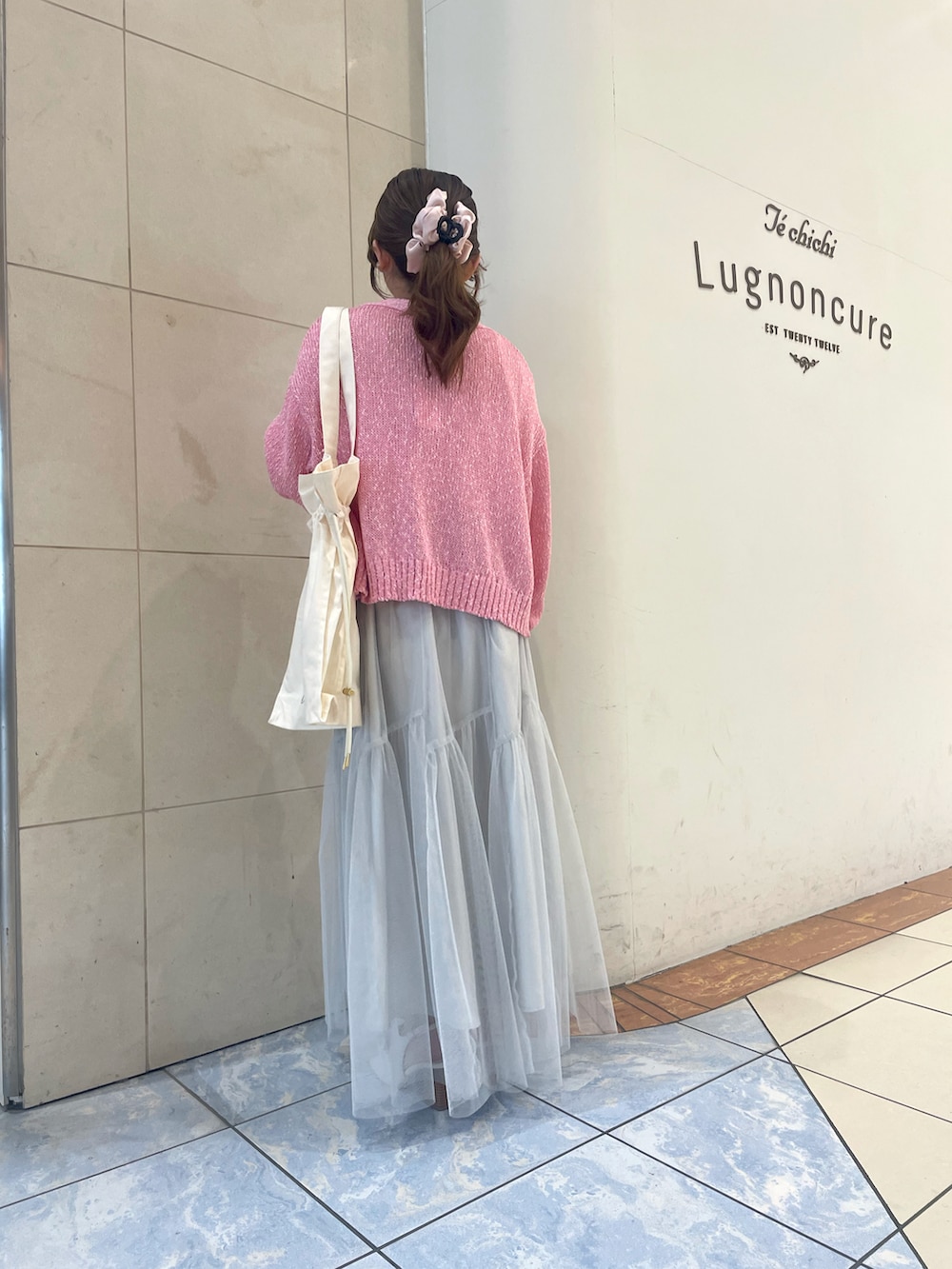 ホワイト系のスカート、ホワイト系のTシャツ/カットソー、ピンク系のカーディガン/ボレロを着用したレディースの春コーディネートの3枚目の写真
