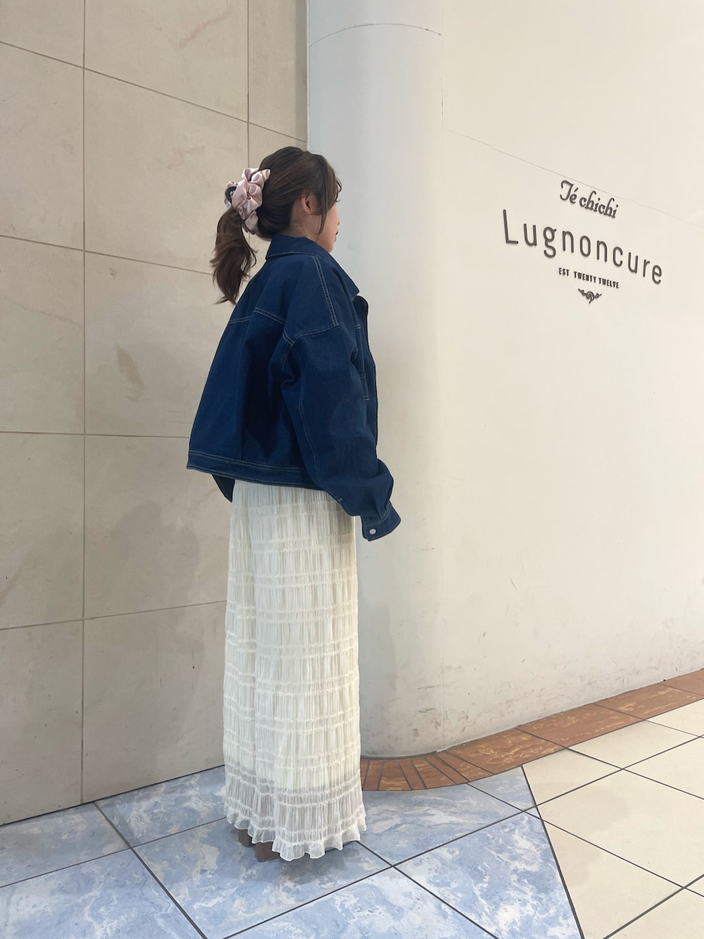 ブルー系のノーカラージャケット、ホワイト系のスカート、ホワイト系のTシャツ/カットソーを着用したレディースの春コーディネートの2枚目の写真