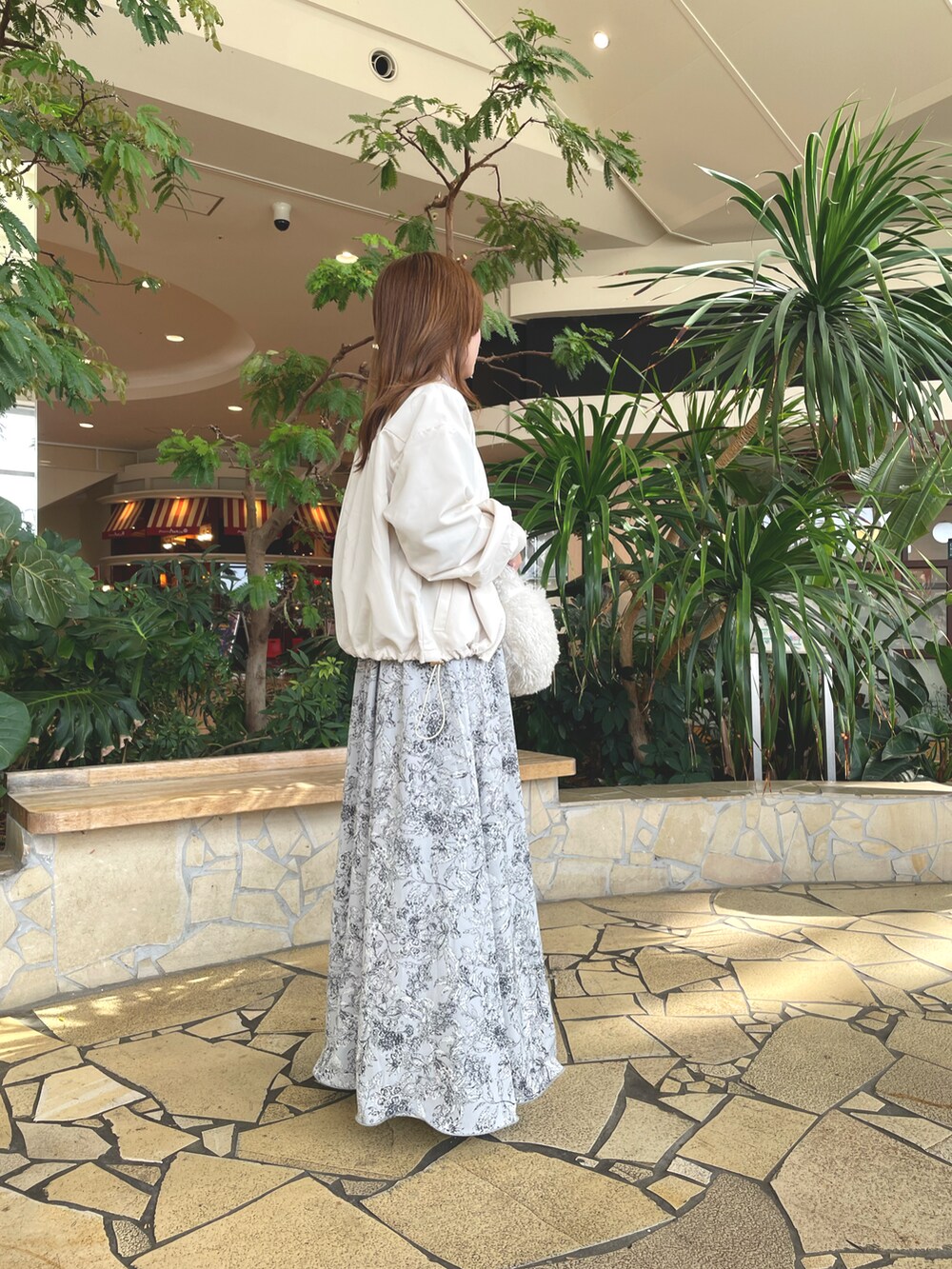 ベージュ系のニット/セーター、ホワイト系のブルゾン、グレー系のスカートを着用したレディースの秋コーディネートの3枚目の写真