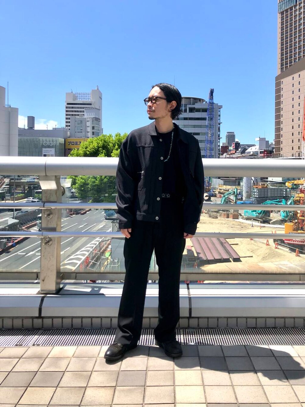 ブラック系のテーラードジャケット、ブラウン系のメガネ、ブラック系のベルトを着用したメンズの夏コーディネートの2枚目の写真