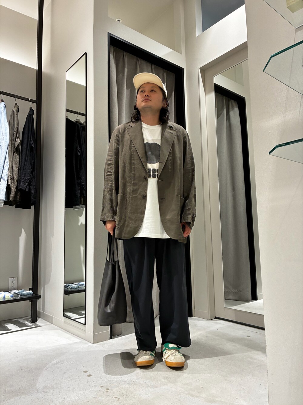 グレー系のトートバッグ、ホワイト系のTシャツ/カットソー、ブラウン系のテーラードジャケットを着用したメンズの夏コーディネートの4枚目の写真